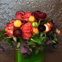 Bouquet of red and yellow roses in a green vase