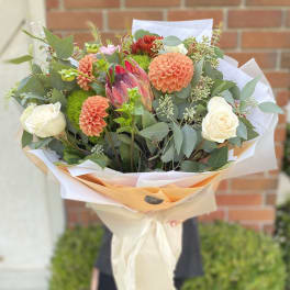 Bouquet of peach dahlias and white roses with greenery
