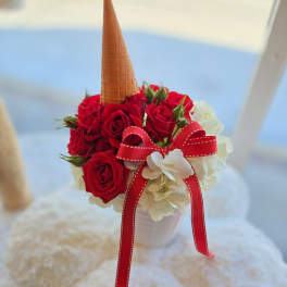 Red roses and white flowers in a small cup with a waffle cone topper