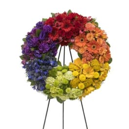 Rainbow floral wreath on a black stand