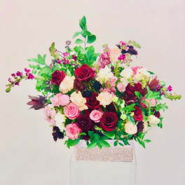 Large bouquet of red, pink, and white flowers in a box