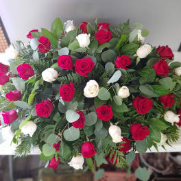 Large bouquet of red and white roses with mixed greenery