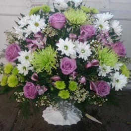 Pink roses and white daisies in a white vase arrangement