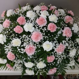 Pink and white carnation casket spray with baby's breath