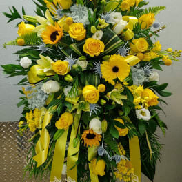 Large yellow and white floral standing spray with ribbons