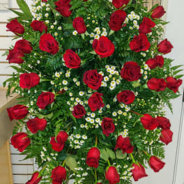 Large standing spray of red roses and white daisies on an easel