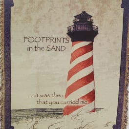 Decorative wall hanging with a lighthouse and the words "Footprints in the Sand"