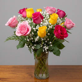 Bouquet of pink, yellow, and red roses in a glass vase