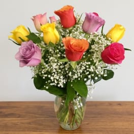 Mixed roses in a clear glass vase with baby's breath