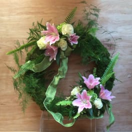 Green wreath with pink lilies and white roses