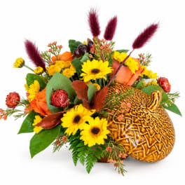 Autumn bouquet with yellow daisies, orange roses, and a gold pumpkin container
