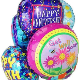 Cluster of colorful foil balloons with happy birthday and happy anniversary messages