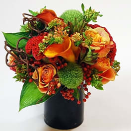 Orange and red floral arrangement in a black vase