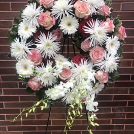 Heart-shaped floral wreath with pink and red roses and white daisies