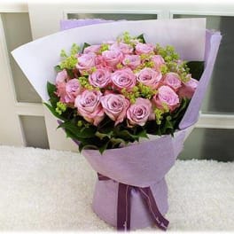 Bouquet of pink roses wrapped in lavender paper