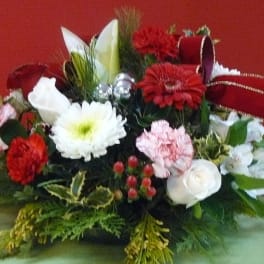 Red, white, and pink floral arrangement with ribbon accents
