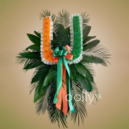 Floral standing tribute with orange and green U-shaped garlands and ribbon bow