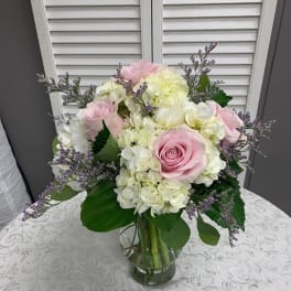 Pink roses and white hydrangeas in a clear glass vase