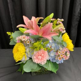 Pink lilies and mixed blooms in a glass vase