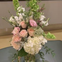 Tall bouquet of pink and white flowers in a glass vase