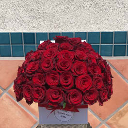 Large bouquet of red roses in a white gift box with a red ribbon