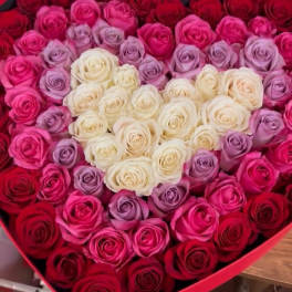 Heart-shaped box filled with red, pink, lavender, and white roses