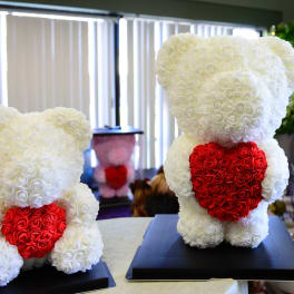 Two teddy bears made of white and red roses on black bases
