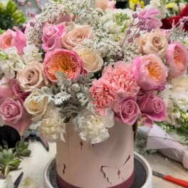 Pink and cream rose bouquet in a round hatbox