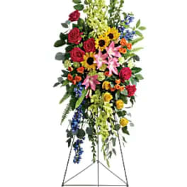 Tall standing floral spray with mixed colorful flowers on an easel