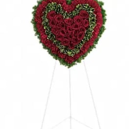 Heart-shaped standing floral spray with red roses and green edging