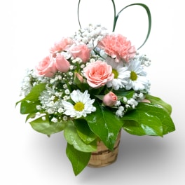 Pink roses and white daisies in a basket with greenery