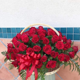 Basket of red roses with a red ribbon bow