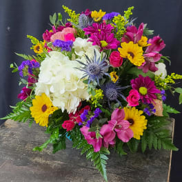 Mixed bouquet with white hydrangea, yellow daisies, and pink flowers