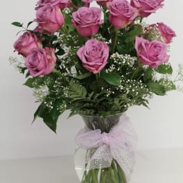 Vase of lavender roses with baby's breath and a sheer polka dot bow