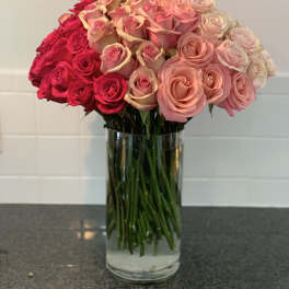 Bouquet of pink and red roses in a clear glass vase