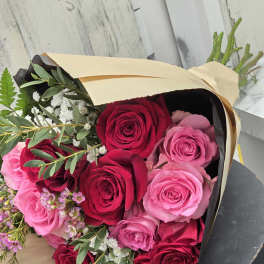 Bouquet of red and pink roses wrapped in paper