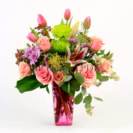Pink and peach mixed bouquet in a tall pink vase