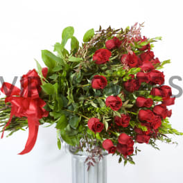 Bouquet of red roses with a red ribbon in a glass vase