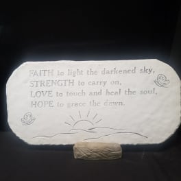 Engraved stone plaque with a hopeful quote on a small stand