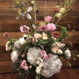 Tall floral arrangement with pink roses, white hydrangeas, and mixed blooms