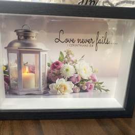 Framed candle and pink-white floral print with a Bible verse