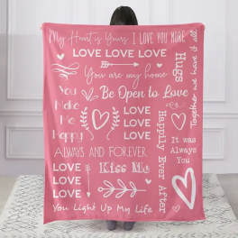 Pink blanket with white love-themed text and heart graphics