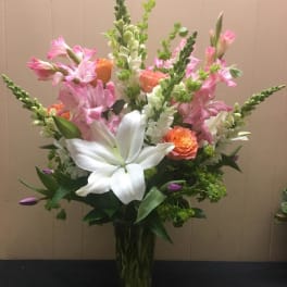 Tall bouquet of pink and white flowers in a clear glass vase