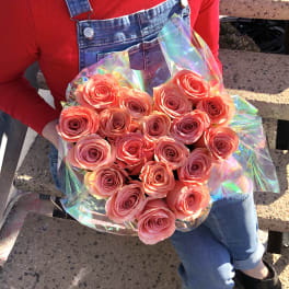 Bouquet of pink roses wrapped in iridescent plastic