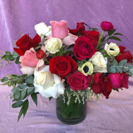 Mixed roses in red, pink, and white arranged in a glass vase
