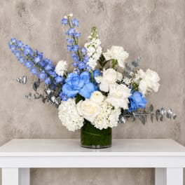 Blue and white floral arrangement in a glass vase