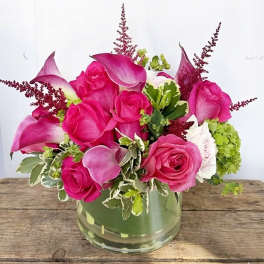 Pink roses and calla lilies arranged in a glass vase