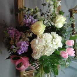 Mixed bouquet of white, pink, and purple flowers in a glass vase
