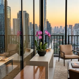Potted pink orchids on a table in a modern room with city views