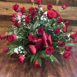 Large bouquet of red roses with greenery and a red ribbon
